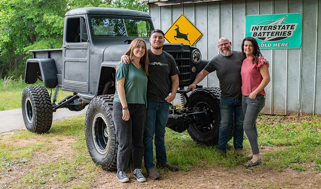 The Farmhouse Auto Sales family standing together at their Fountain Inn dealership